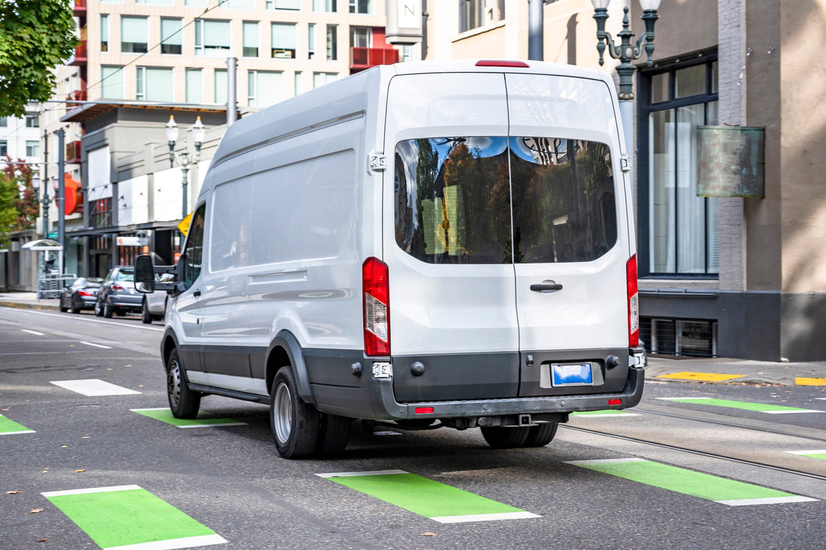 White Sprinter Van driving down the street