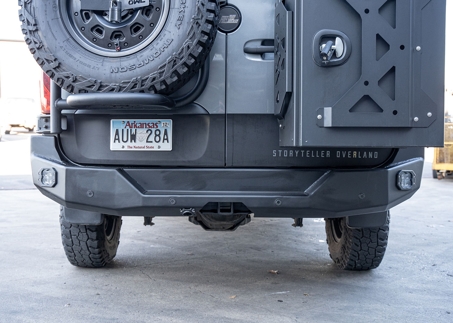 Direct rear view of a Mercedes Sprinter van featuring the ROAMBUILT Rear Bumper, showcasing the full replacement aluminum bumper with integrated step, dual light pockets, and compatibility with parking sensors, blind spot assist, and OEM receiver hitch—designed for durability, utility, and off-road performance.