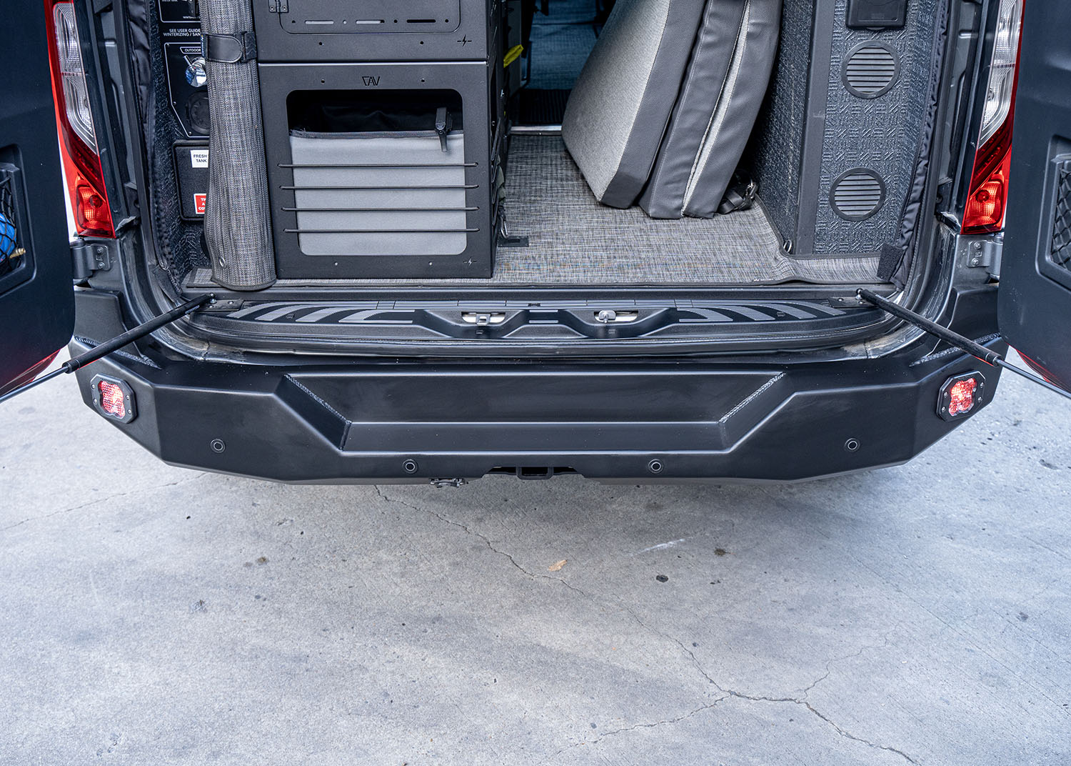 Top-down view of the ROAMBUILT Rear Bumper on a Mercedes Sprinter van, highlighting the built-in step and its alignment with the rear cargo area for easy access, with durable aluminum construction and textured surface for secure footing.