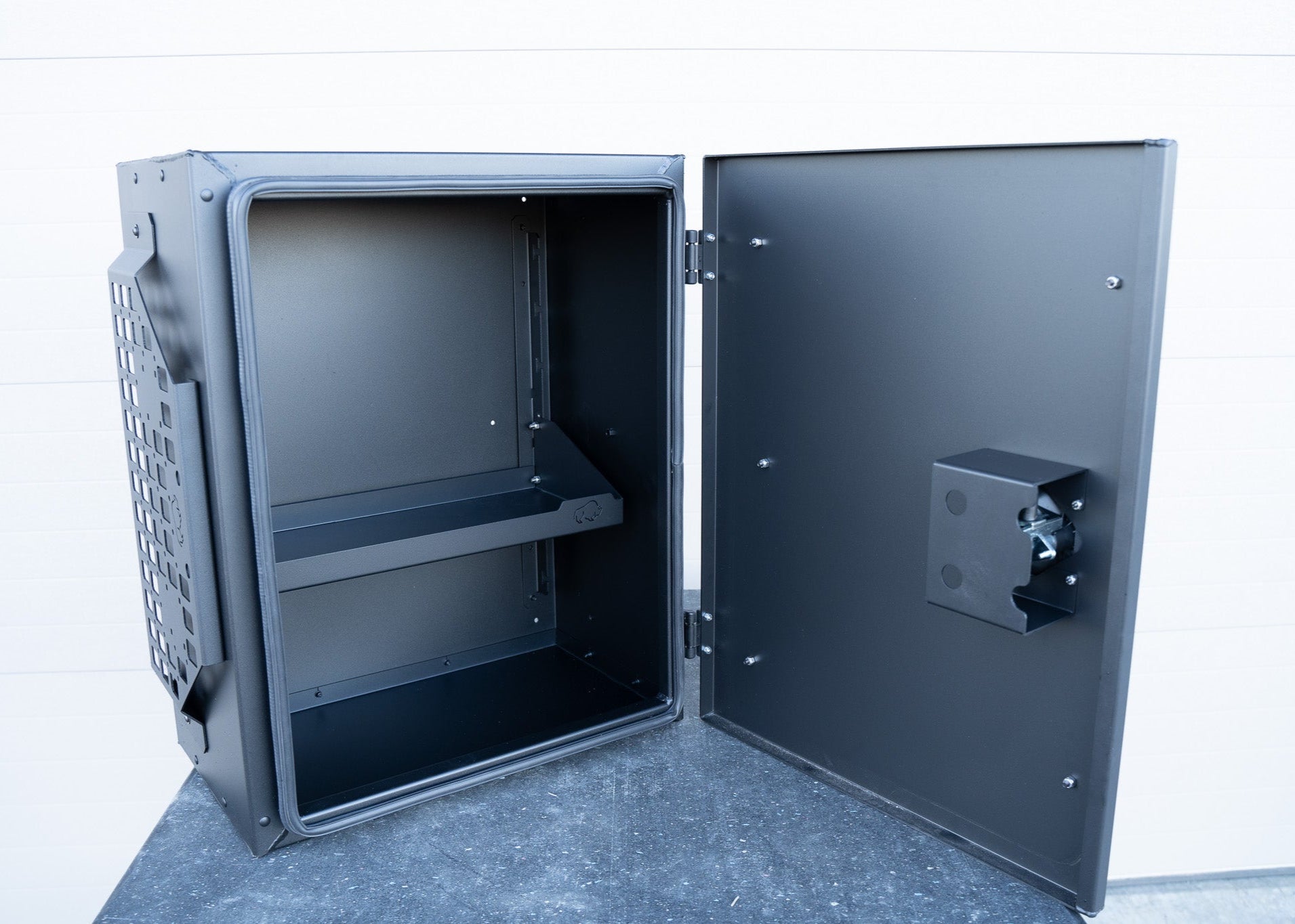 ROAMBUILT Universal Aluminum Storage Box with door open, showing adjustable shelf inside and black automotive-grade gasket lining the door for water and dust resistance.