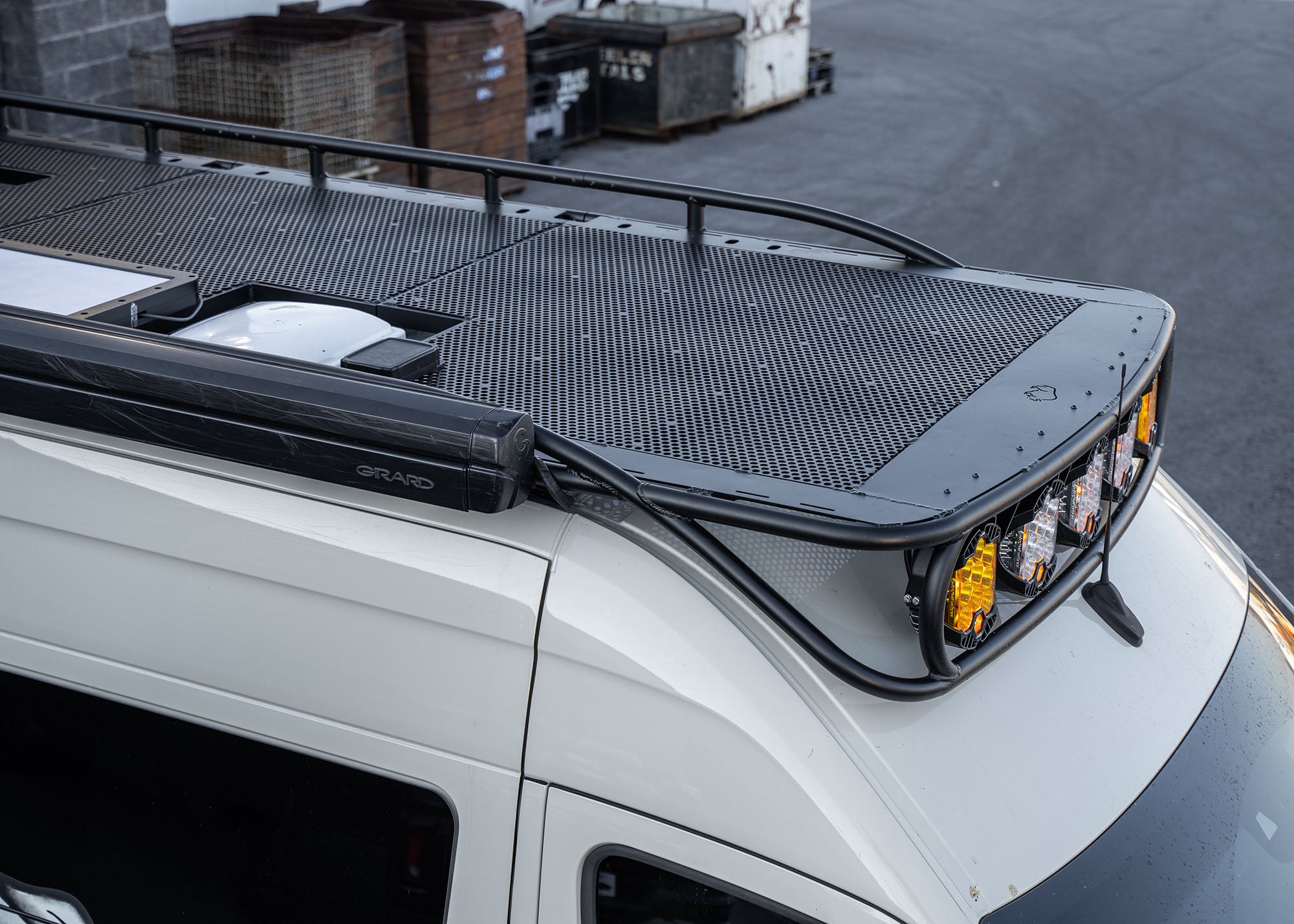 Passenger side front view of the ROAMBUILT Safari 2.0 roof rack setup, featuring mounted awning, Starlink satellite, MaxxAir fan, and Baja Designs lights—all integrated for ultimate overland functionality.