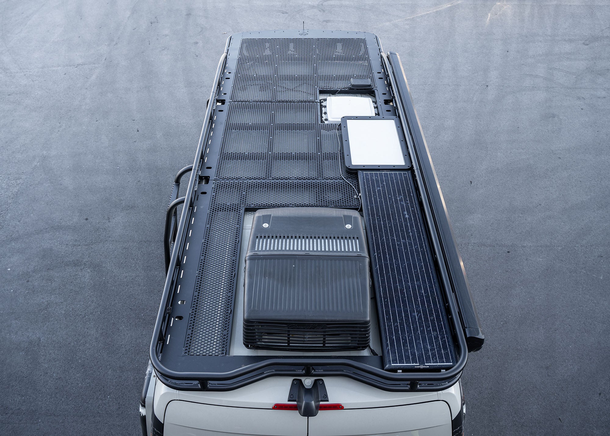 Overhead view from the rear showing the entire ROAMBUILT Safari 2.0 roof rack with curved front, perforated decking, and modular 3- or 4-piece design for 2007+ Sprinter vans.