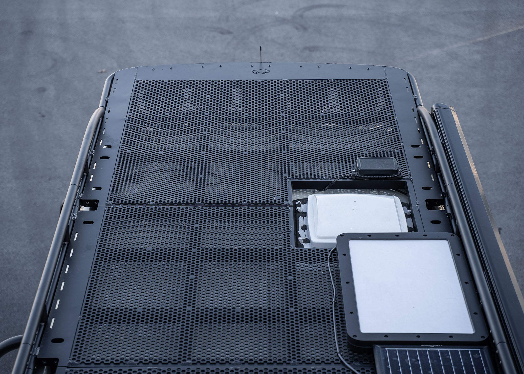 Top view from mid to front of the ROAMBUILT Safari 2.0 roof rack, featuring the Starlink satellite dish, Zamp Solar panel, and Maxxair fan installed for optimized off-grid living.