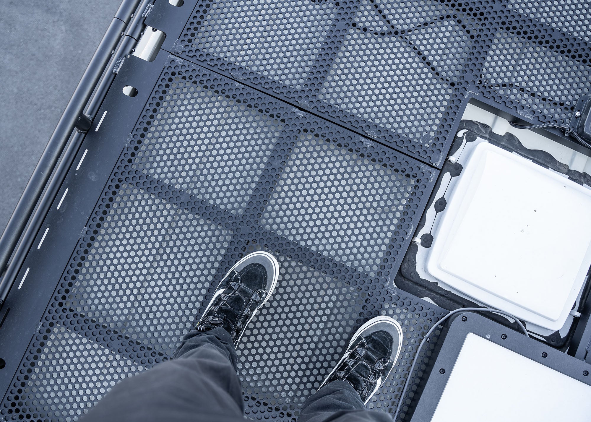 Top view close-up of the ROAMBUILT Safari 2.0 roof rack connection point, showing the secure bolt-on hardware and sturdy 5052 aluminum construction.