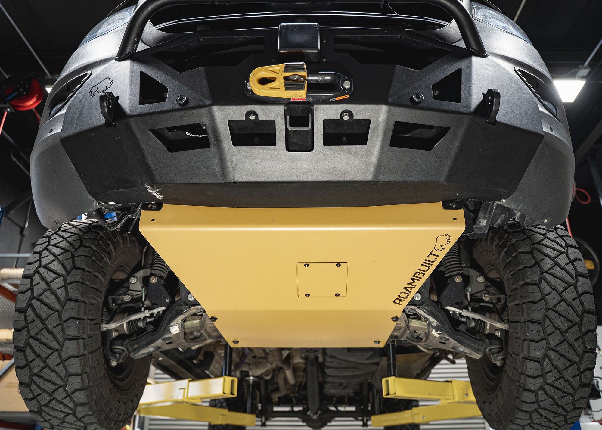 Underside view of the Roambuilt Mercedes Sprinter skid plate showing the removable oil change access panel, mounted together with the LoPro front bumper for full front-end protection.