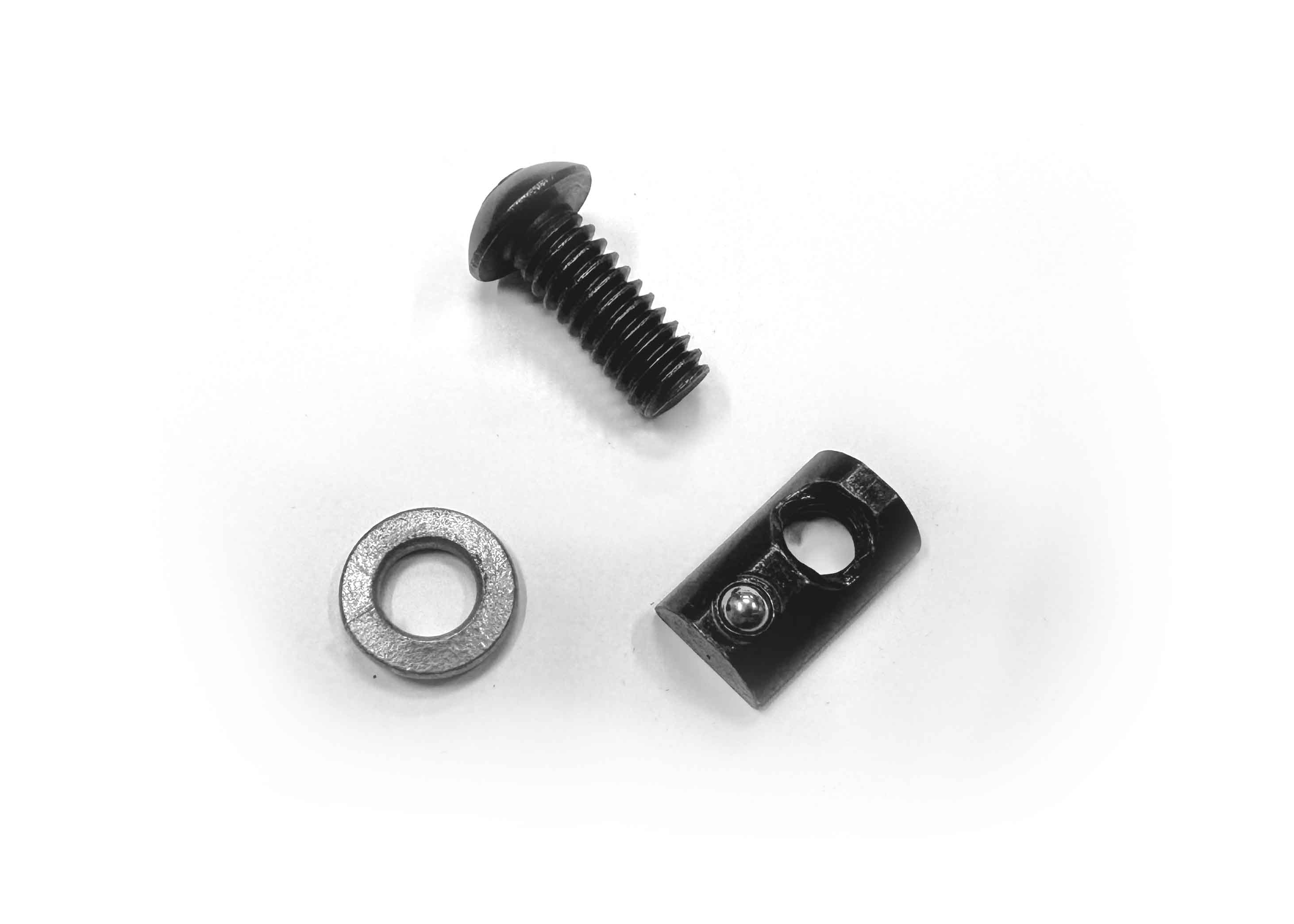 Close-up of individual black oxide bolt, lock washer, and slide-in T-nut laid out side by side, showing key mounting hardware for ROAMBUILT Flatpack Roof Racks.