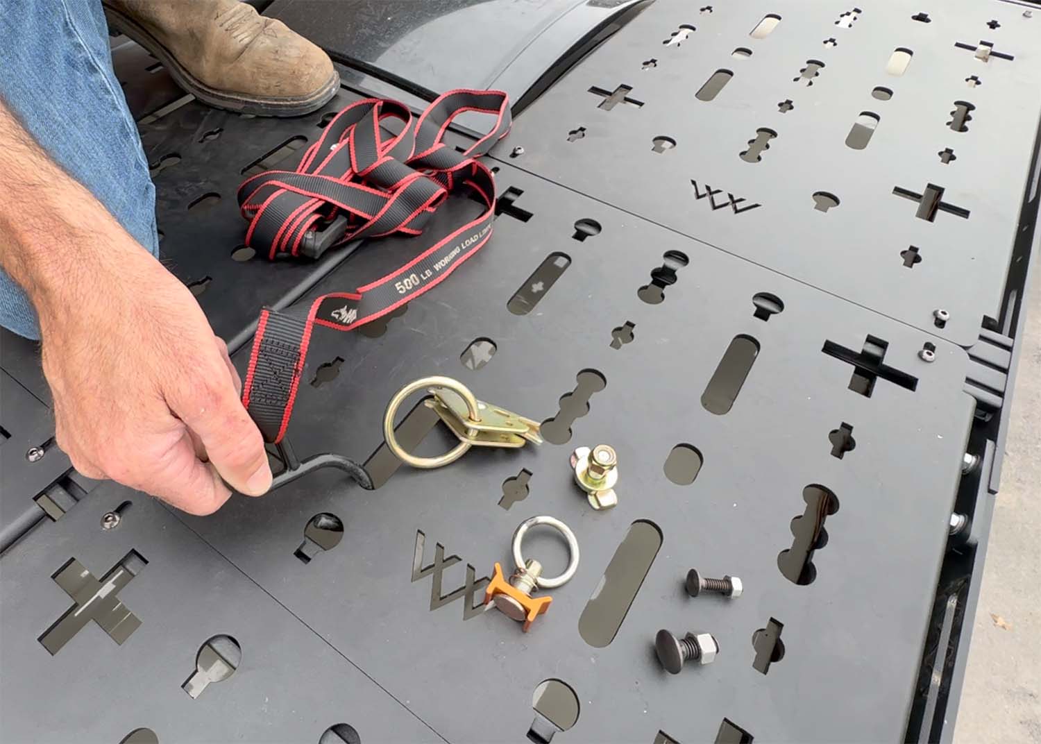 Top view showing ROAMBUILT roof rack deck panels with multiple mounting locations and various gear attachments for versatile roof storage.