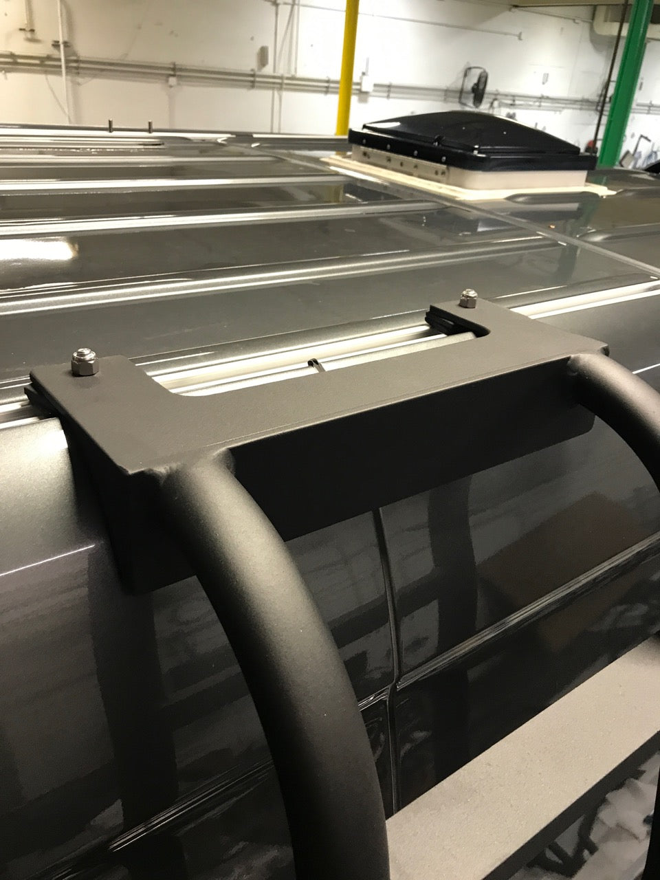 Close-up driver side view of a Mercedes Sprinter van showing the ROAMBUILT Straight Side Ladder securely mounted into the factory roof rail, with visible mounting hardware and no roof rack installed.